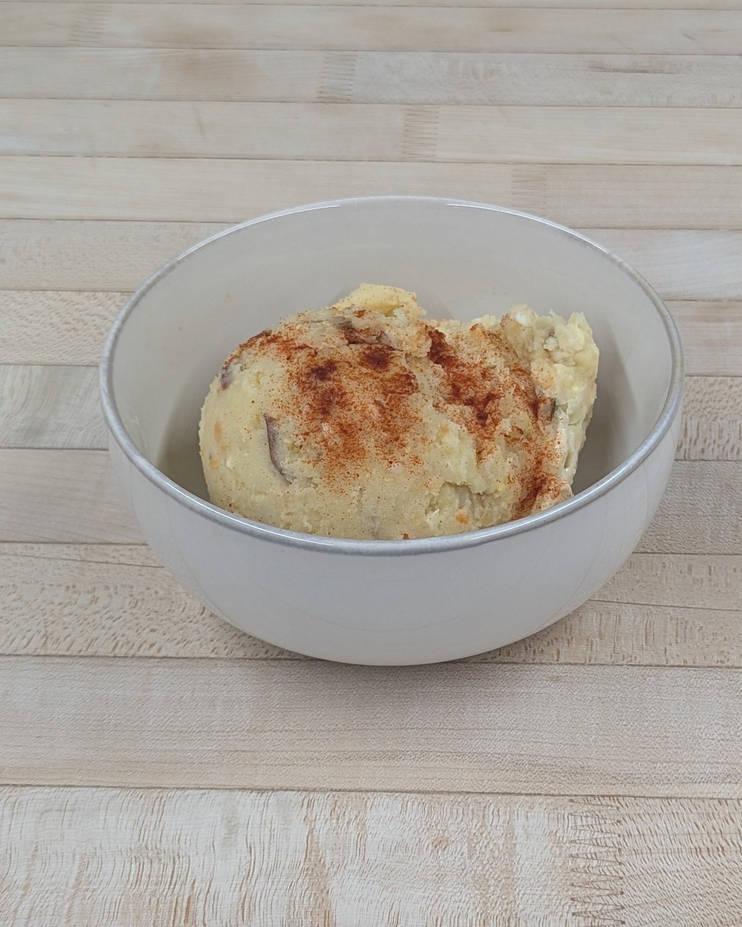 Bowl of potato salad on a wooden surface