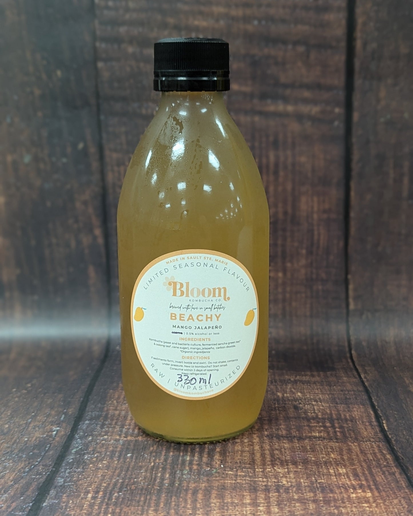 Bottle of 'Bloom' kombucha on a wooden surface