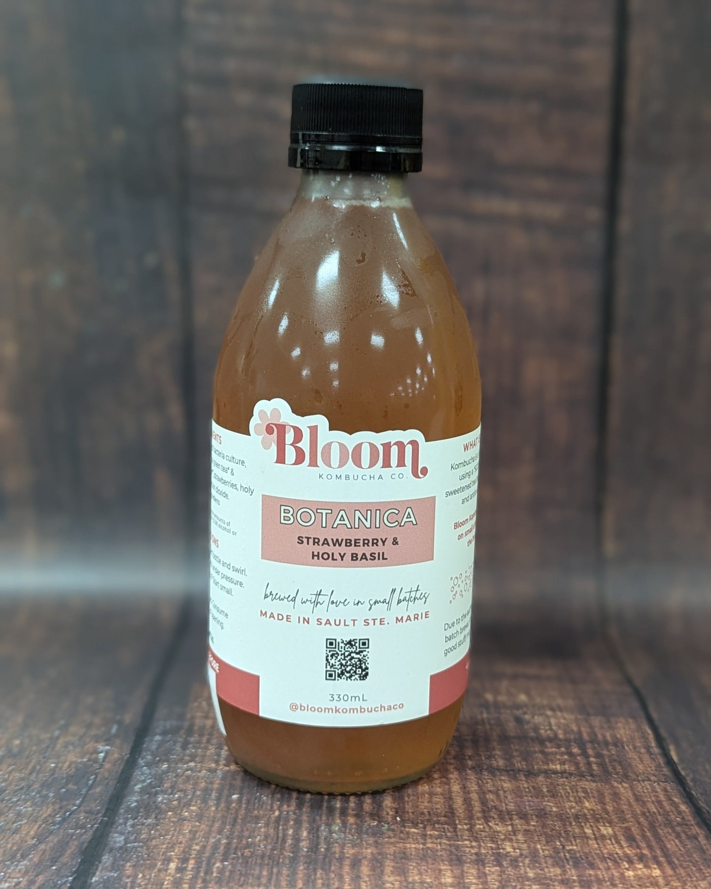 Bottle of 'Bloom' kombucha on a wooden surface