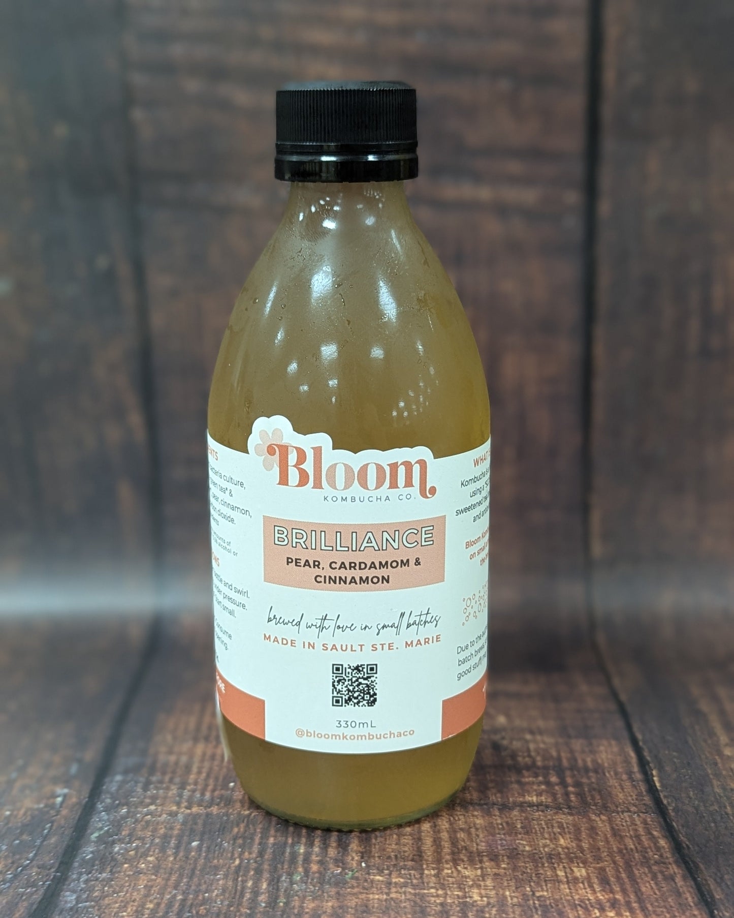 Bottle of 'Bloom' kombucha on a wooden surface