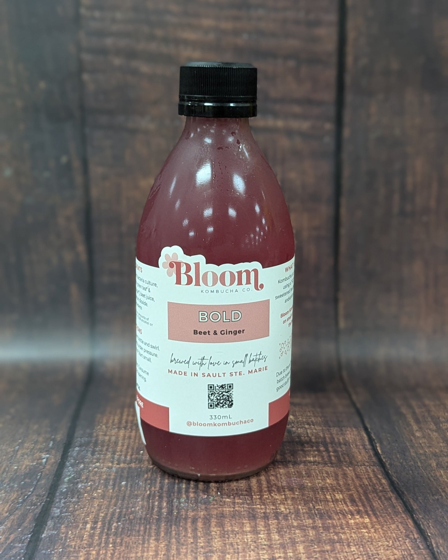 Bottle of 'Bloom' kombucha on a wooden surface