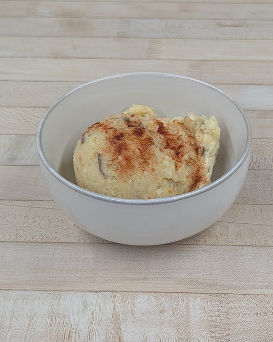 Bowl of potato salad on a wooden surface