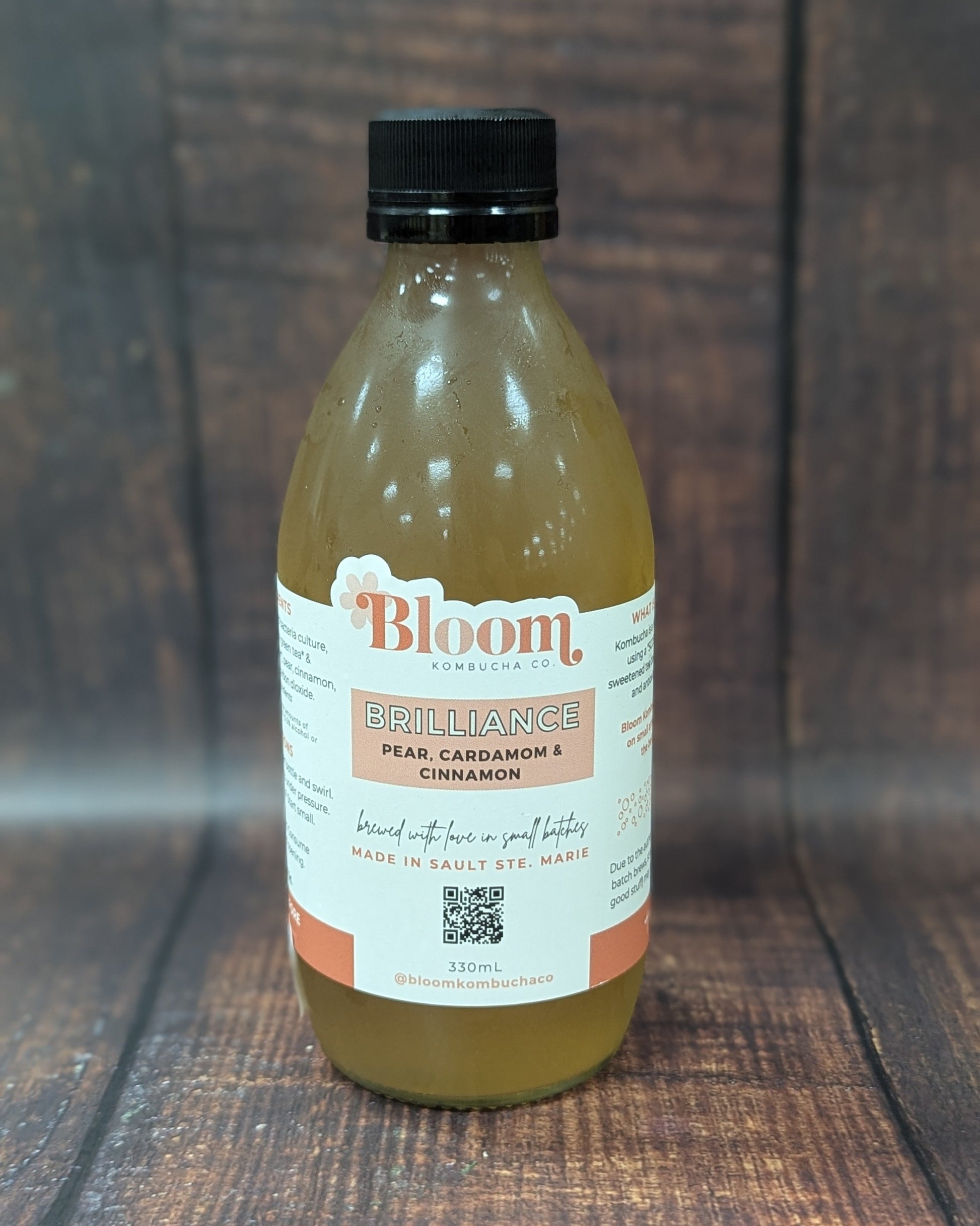 Bottle of 'Bloom' kombucha on a wooden surface
