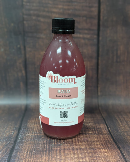 Bottle of 'Bloom' kombucha on a wooden surface